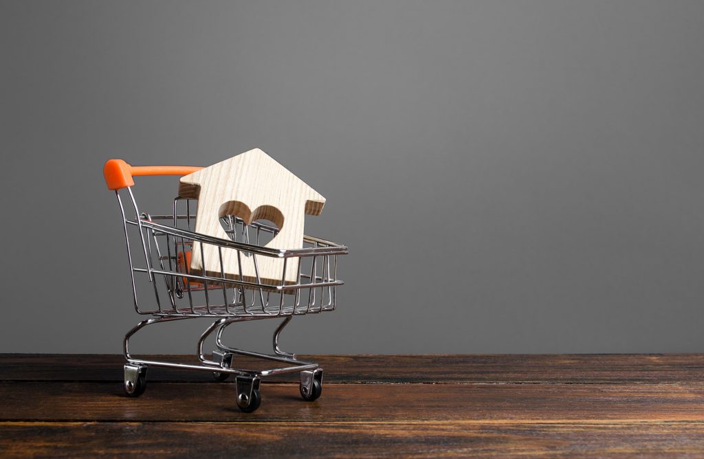 tiny wooden house shape with a heart in a mini shopping cart to reflect blog topic, titled mortgage renewal: shopping for a better mortgage rate?